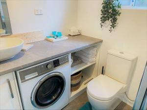 a bathroom with a washing machine and a sink at Salt & Soul Beach Shack in Esperance