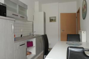 uma cozinha com um lavatório e uma mesa com cadeiras em Erholung im Herzen von Mühlhausen em Mühlhausen