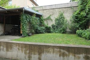 Erholung im Herzen von Mühlhausen في مولهاوزن: حديقة خلفية مع ساحة عشبية بجوار مبنى