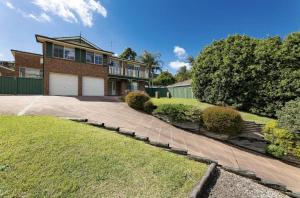 una casa in mattoni con un vialetto di fronte di 10 Minnibah Circuit a Forster