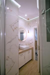 La salle de bains est pourvue d'un lavabo et d'un miroir. dans l'établissement Thalia by Heloni Apartments, à Athènes