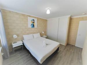 een slaapkamer met een bed met een witte sprei bij Sea Stays Esperance in Esperance