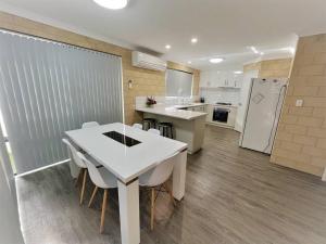 a kitchen with a white table and chairs in it at Sea Stays Esperance in Esperance