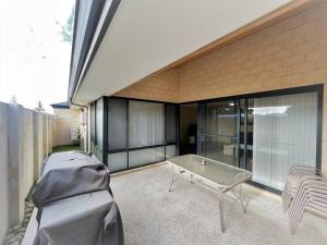 a patio with a table and a bench in front of a building at Sea Stays Esperance in Esperance