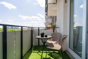 a balcony with a small table and two chairs at ApartamentySnu, Wola Komfort II z parkingiem in Warsaw