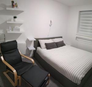 a bedroom with a bed and a chair at Town House Chantry - With Self Check In and Free Parking - Rooms at ipswichdigs in Ipswich