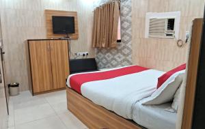 a small bedroom with a bed and a television at Swapna International in Mumbai