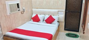 a bed with red and white pillows in a room at Swapna International in Mumbai