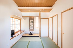 Zimmer mit grünem Boden und Holzdecken in der Unterkunft Miyajima Fujinoya Female Only in Miyajima