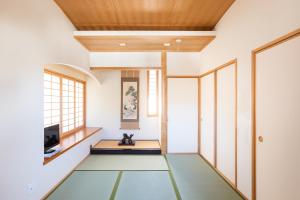 宮島にある宮島 女性限定のお宿 藤のやの木製の天井が特徴の緑の床の客室