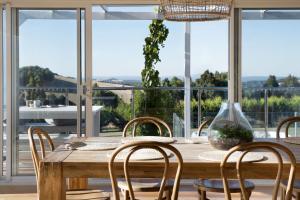 a dining room with a wooden table and chairs at Musk Springs in Bullarto