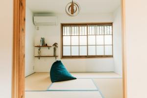 Tokuto"Queen Villa" - Vacation STAY 81603v في Ieura: وسادة زرقاء موضوعة على الأرض في غرفة بها نافذة