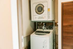 a washer and dryer in a bathroom with a washing machine at Tokuto"Queen Villa" - Vacation STAY 81603v in Ieura