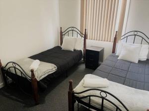 a bedroom with two beds and a night stand at Six By The Beach in Esperance