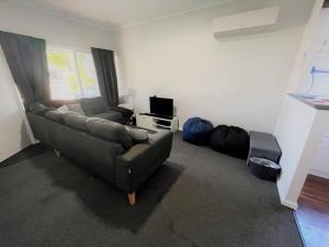 a living room with a couch and a television at Six By The Beach in Esperance