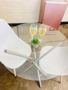 a table with two glasses of wine and a plant at Affordable Guest Room @260Main in Johannesburg