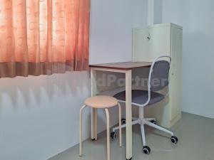 een bureau met een stoel, een bureau en een kast bij Adam Guesthouse Mitra RedDoorz in Bogor