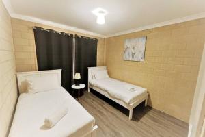 a small room with two beds and a window at Stay By The Sea Esperance in Esperance