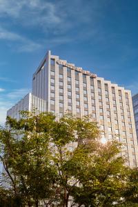 a tall building with trees in front of it at LOTTE City Hotel Guro in Seoul