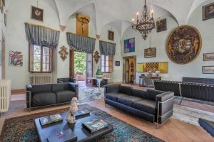 a living room with couches and a chandelier at Villa Sardi Small Luxury boutique Hotel in Lucca