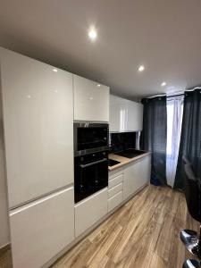 a kitchen with white cabinets and black appliances at Appartement Gare Saint Charles in Marseille