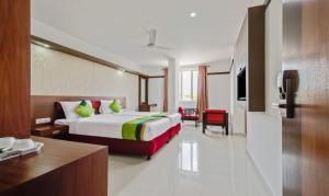 a hotel room with a bed and a desk at Amala's Residency in Trivandrum