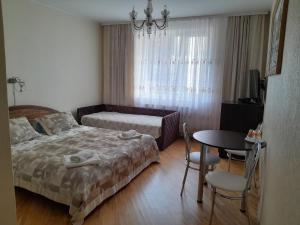 een hotelkamer met een bed en een tafel en stoel bij Vila Uosis in Palanga