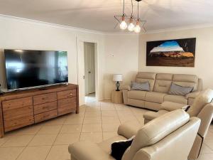 sala de estar con TV de pantalla plana grande en The Sundowner, en Esperance