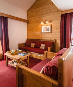 Habitación con cama, sofá y mesa. en Lagrange Vacances Les Hauts de Comborcière, en La Toussuire