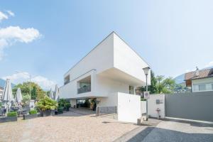 uma casa branca com um telhado pontudo em Soley Suites - adults only em Bressanone