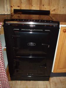 um forno preto está sentado numa cozinha em Vemdalsskalsgården em Vemdalen