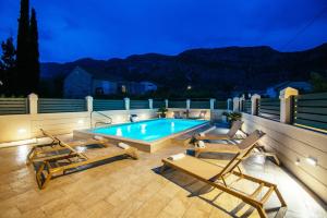 a swimming pool with chaise lounges on a patio at Apartments Azzurro in Komolac
