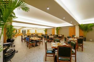 Anantam Resort & Spa في كاساولى: مطعم بالطاولات والكراسي والنباتات