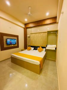 a bedroom with a large bed and a tv at Golden Lotus Varanasi in Varanasi