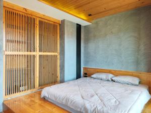 a bedroom with a bed and a wooden wall at 6 floor - ReLife The Windy near Nai Harn beach by 20 minutes walking in Rawai Beach