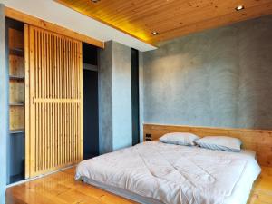 1 dormitorio con 1 cama y pared de madera en 6 floor - ReLife The Windy near Nai Harn beach by 20 minutes walking en Rawai Beach