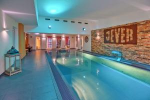 uma grande piscina com uma parede de tijolos em Hotel Im Schützenhof, Jever em Jever