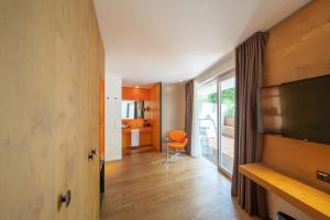 ein Wohnzimmer mit einem TV und einem Stuhl in der Unterkunft Soley Suites - adults only in Brixen