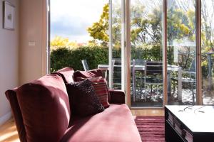 a living room with a couch and a large window at Orford Panache in Daylesford