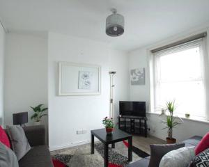 uma sala de estar com um sofá e uma televisão em City Centre 4 Bedroom-Sleeps 8! em Winchester