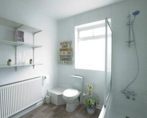 uma casa de banho branca com um WC e um chuveiro em City Centre 4 Bedroom-Sleeps 8! em Winchester