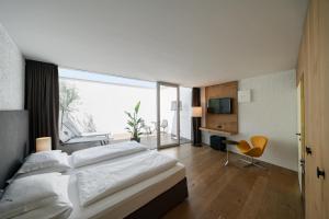 um quarto com uma cama grande e uma janela grande em Soley Suites - adults only em Bressanone