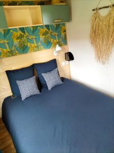 a bed in a room with four pillows on it at Cottage gîte aux Lauriers Lacroix sur meuse in Lacroix-sur-Meuse