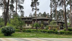 a house sitting in the middle of a forest at Spa-Hotel Myslyvskiy Dvir in Kyiv