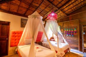 a bedroom with two beds and a chandelier at Salim Beach Resort in Gili Air