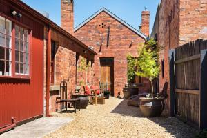 a courtyard of an old brick building with plants at Persimmon in Clunes