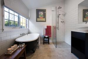 a bathroom with a tub and a sink at Persimmon in Clunes