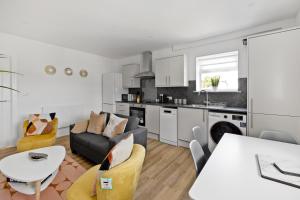 a kitchen and living room with a couch and a table at Stylish Great Location Near Tamar Bridge in Saltash