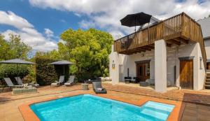 a villa with a swimming pool and a house at B&B Sauvignon Country Lodge in Wellington