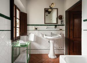 Baño blanco con lavabo y espejo en Villa La Cappella en Montespertoli